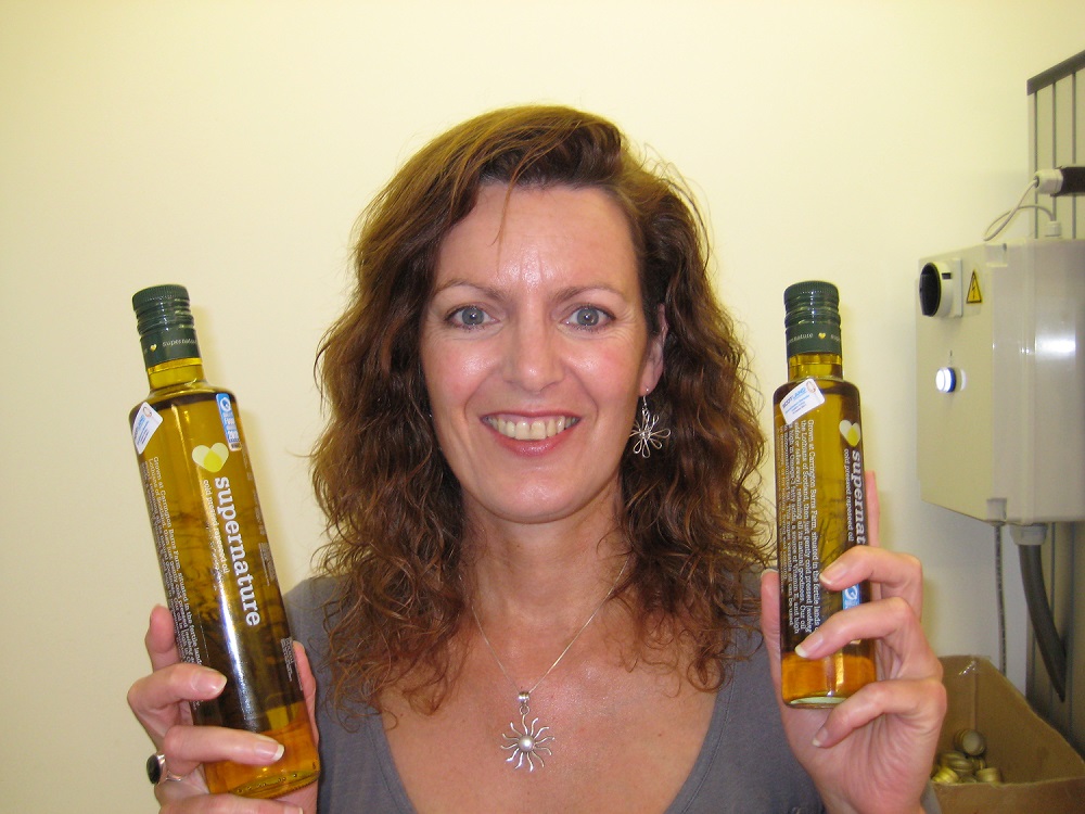 Woman holding 2 bottles of oil and smiling