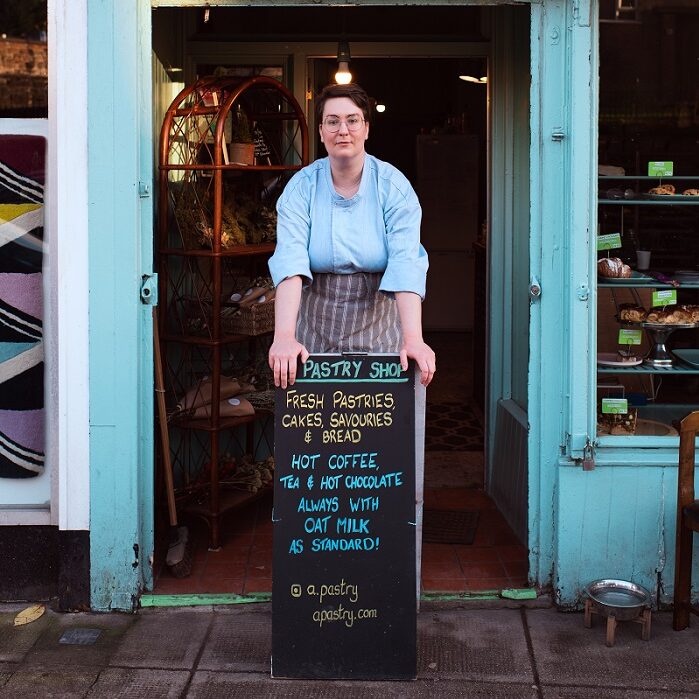 woman standing in front of a bakery door
