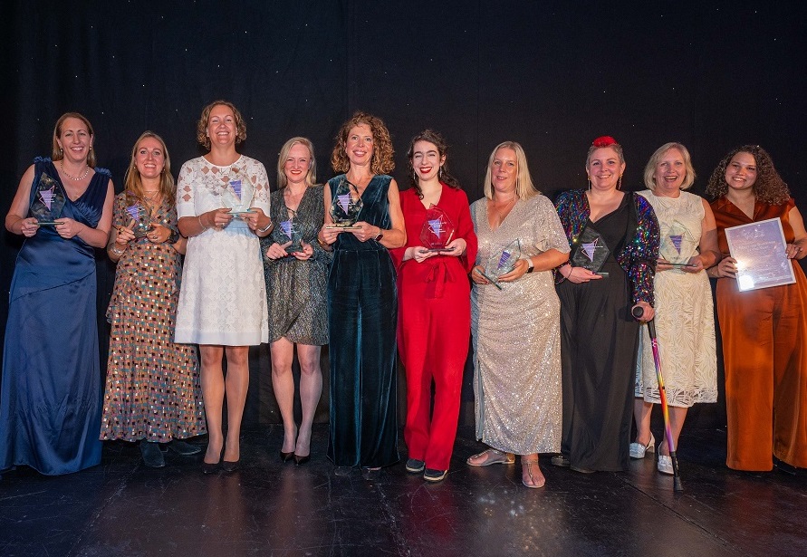 women holding awards and smiling